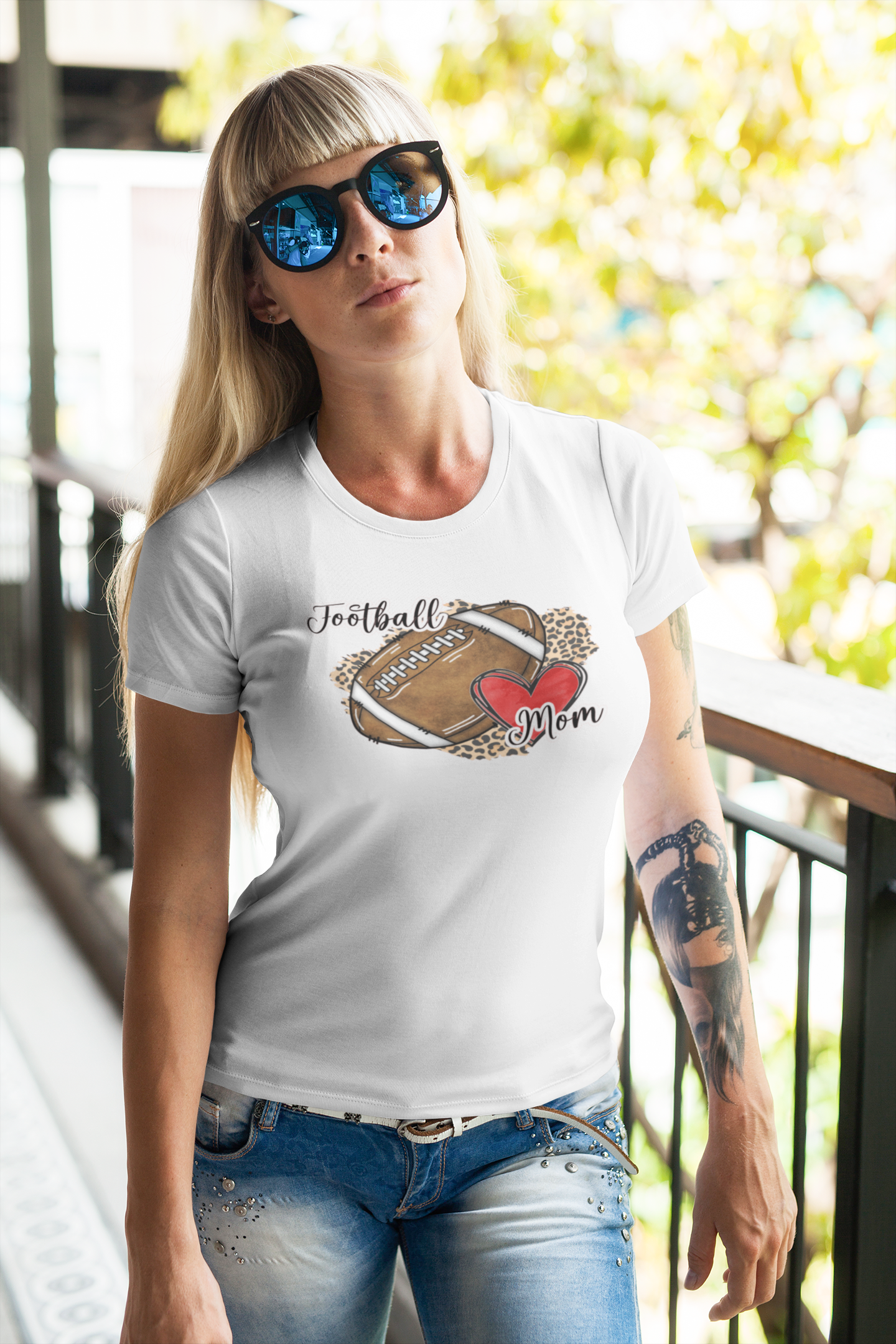 white T-shirt with 'Football Mom' graphic, featuring a leopard print background, football design, and red heart.