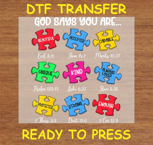 "God Says You Are DTF Transfer with colorful puzzle pieces and Bible verses promoting autism awareness and faith"