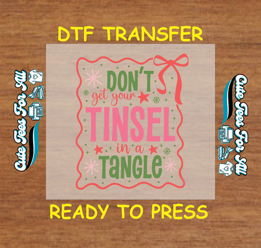 Christmas DTF transfer with phrase Don’t Get Your Tinsel in a Tangle in pink and green with festive bow and stars, ready to press dtf heat transfer