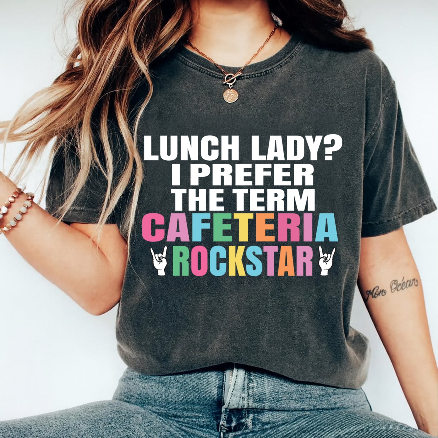 Person wearing a t-shirt with colorful text design on a plain background