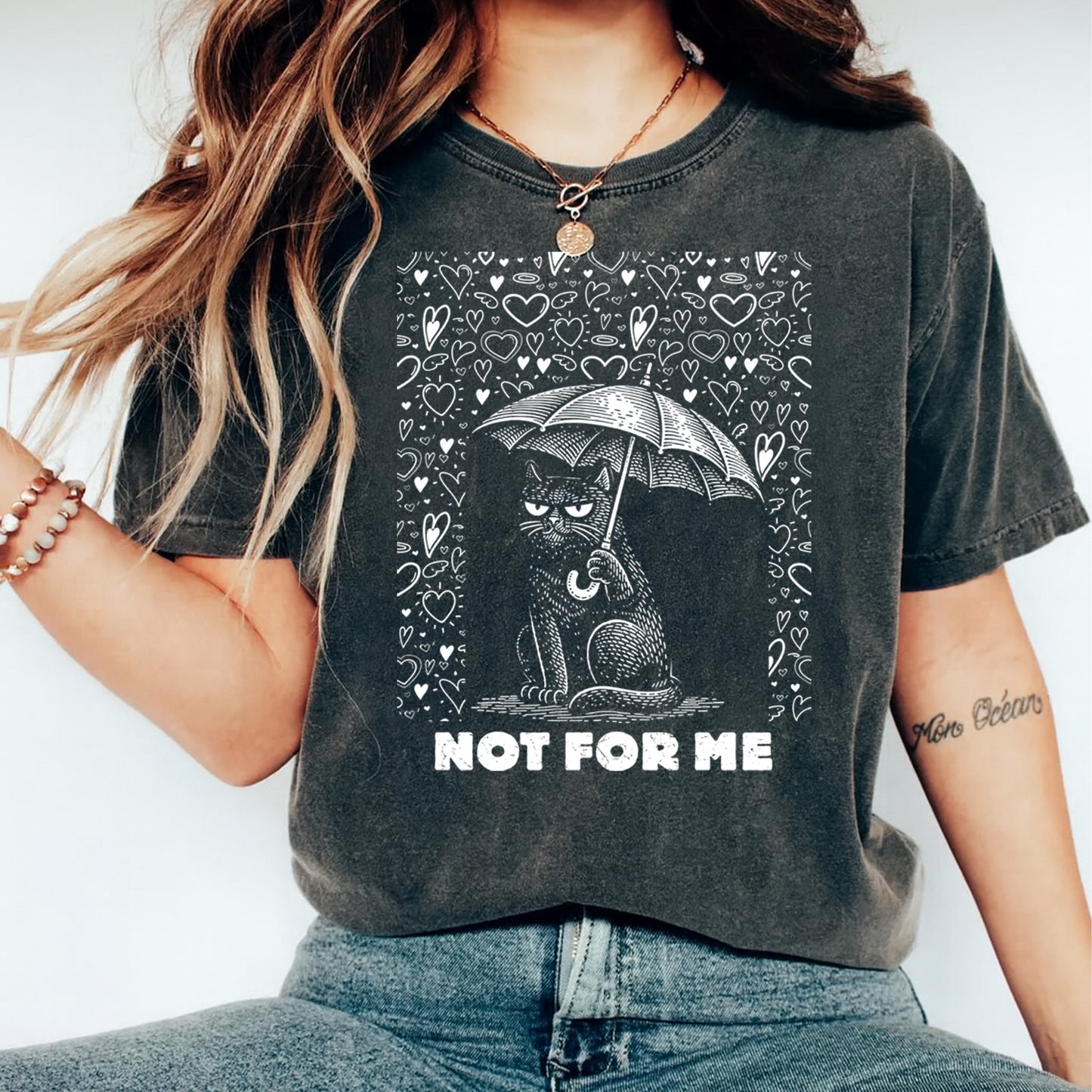 Dark gray t shirt mockup showing a grumpy black cat holding an umbrella surrounded by hearts with the text Not For Me, sarcastic Valentine graphic tee