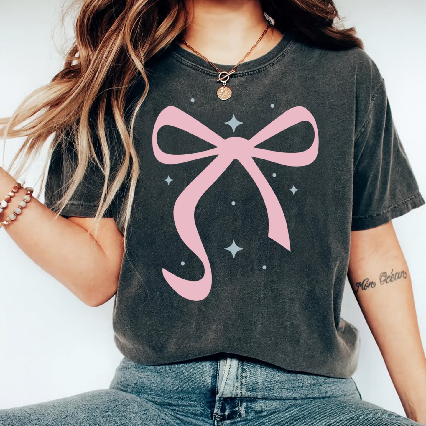 Pink bow graphic shown on dark t shirt mockup with clean girly aesthetic and minimal design style