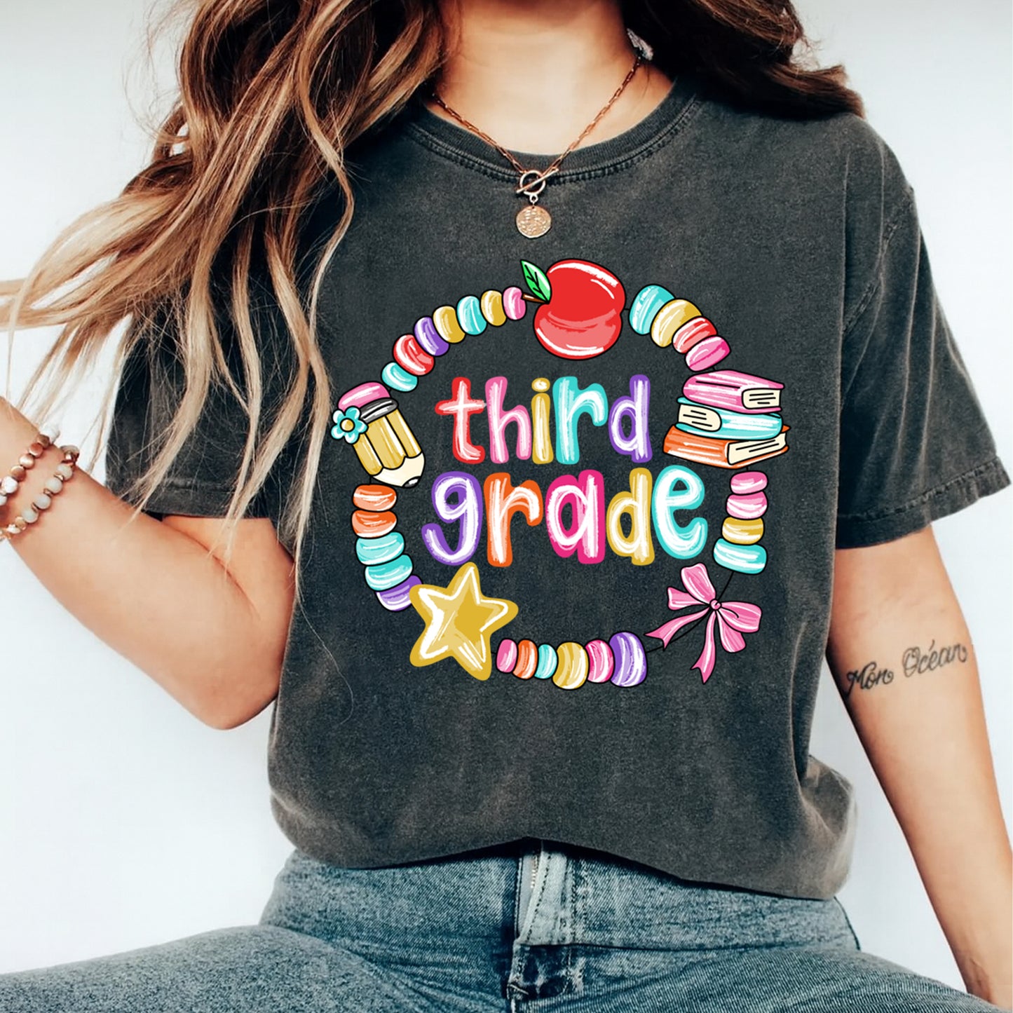 Third grade teacher shirt mockup showing colorful apple and book school graphic pressed on dark gray t shirt