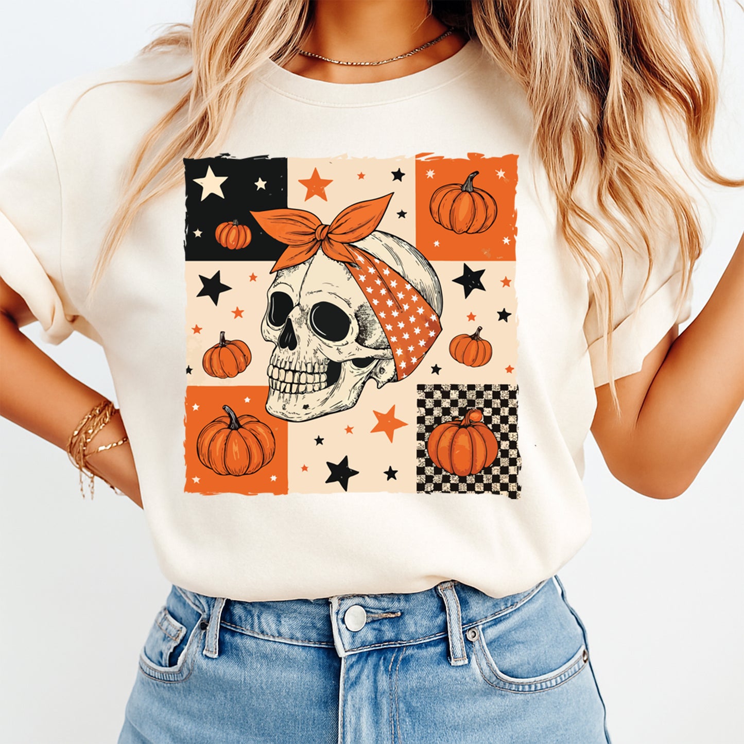 Halloween skull with pumpkin bow patchwork graphic pressed on a cream t shirt showing fall pumpkin and star artwork