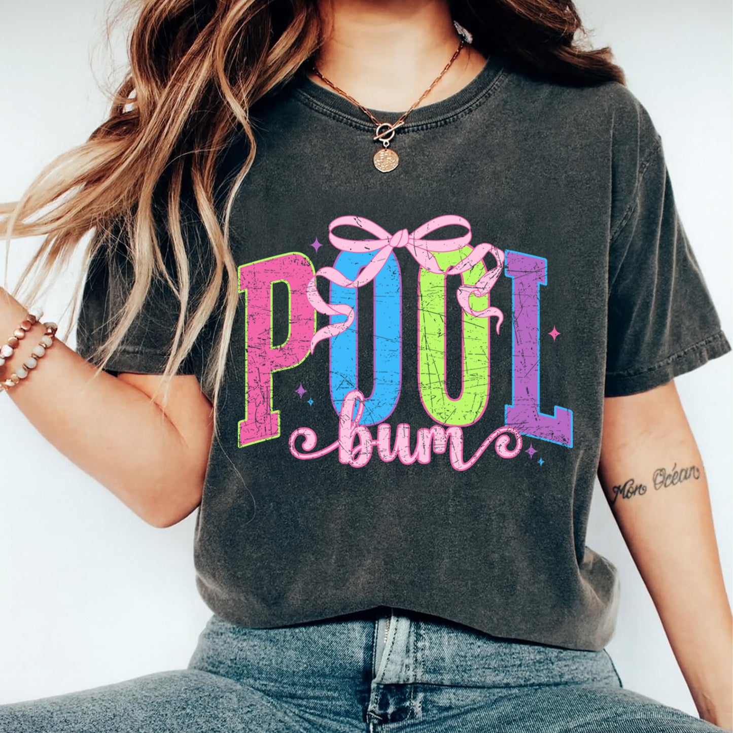 Pool Bum retro graphic printed on t shirt featuring bright neon letters and pink bow summer design