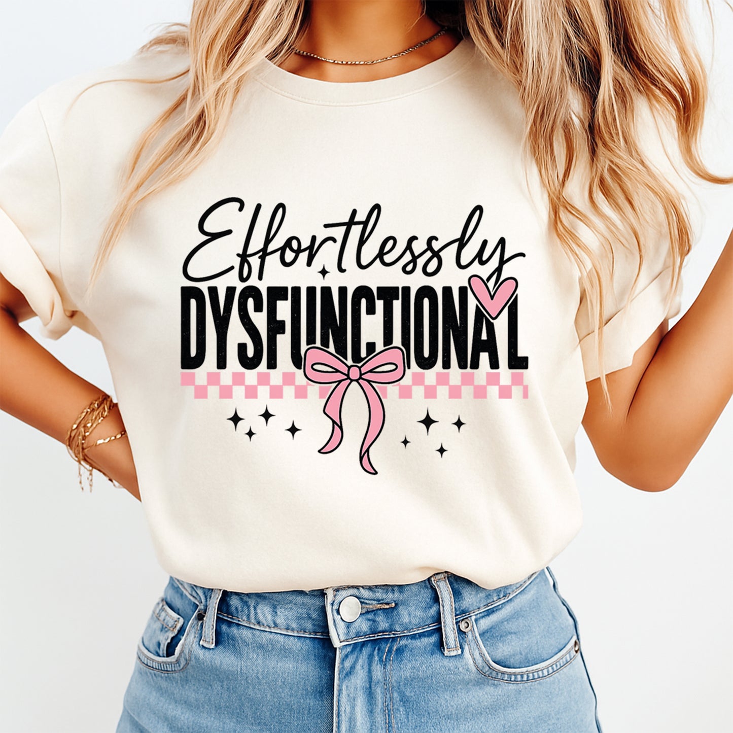 Woman wearing beige shirt with Effortlessly Dysfunctional pink bow heat transfer graphic on front