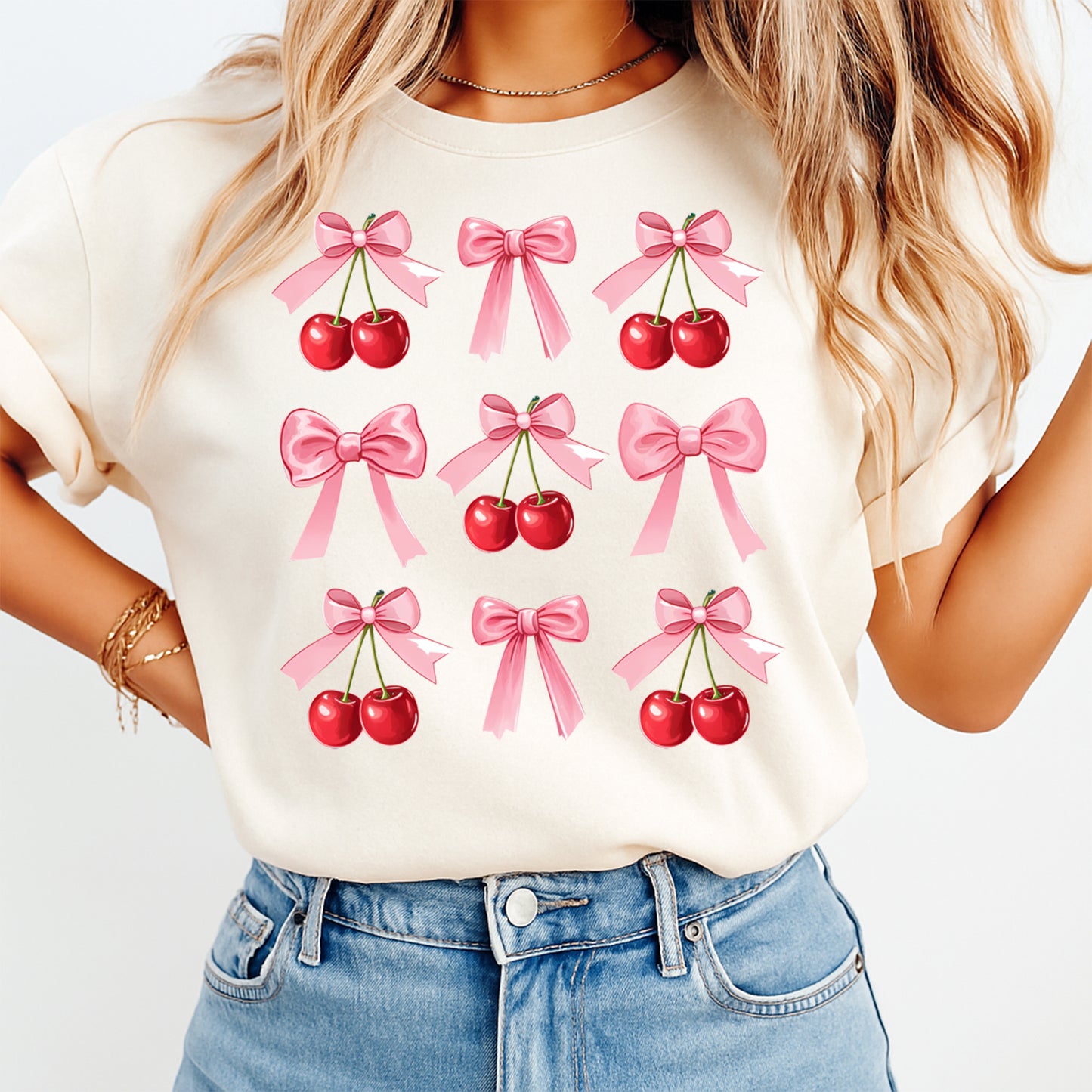 Pink bow and red cherry pattern graphic printed on cream shirt with repeating layout design