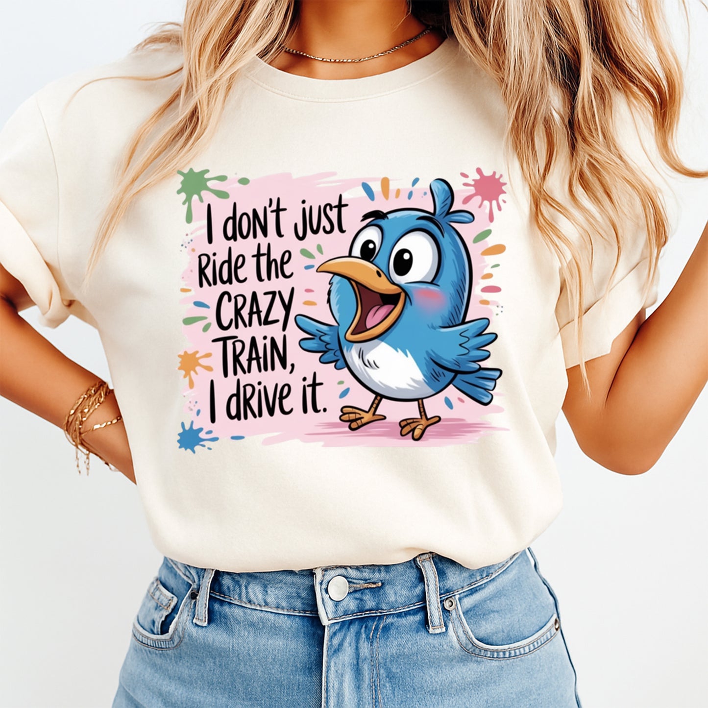Woman wearing a cream shirt with a funny blue bird ready to press dtf graphic and colorful splash background on the front