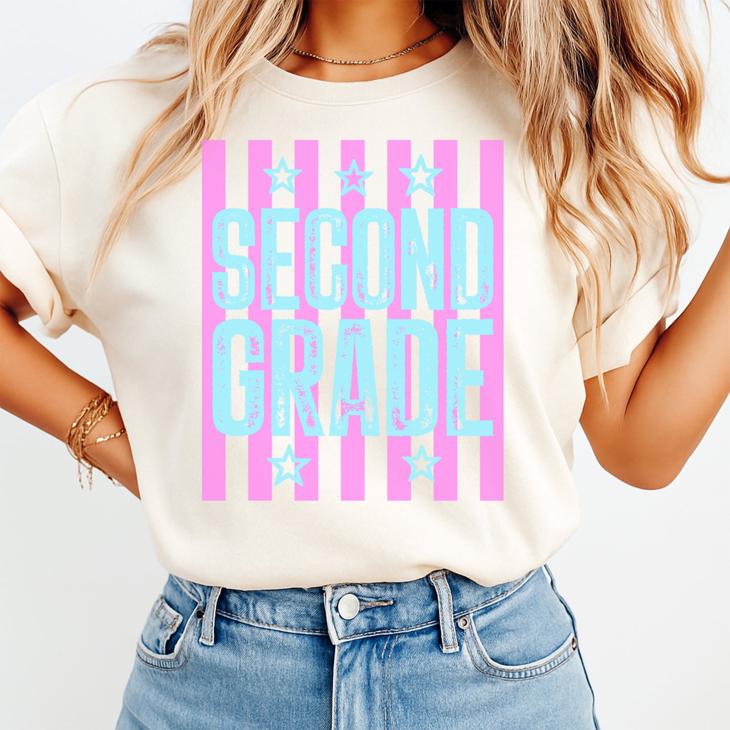 Person wearing a white t-shirt with 'SECOND GRADE' text and pink stripes on a plain background