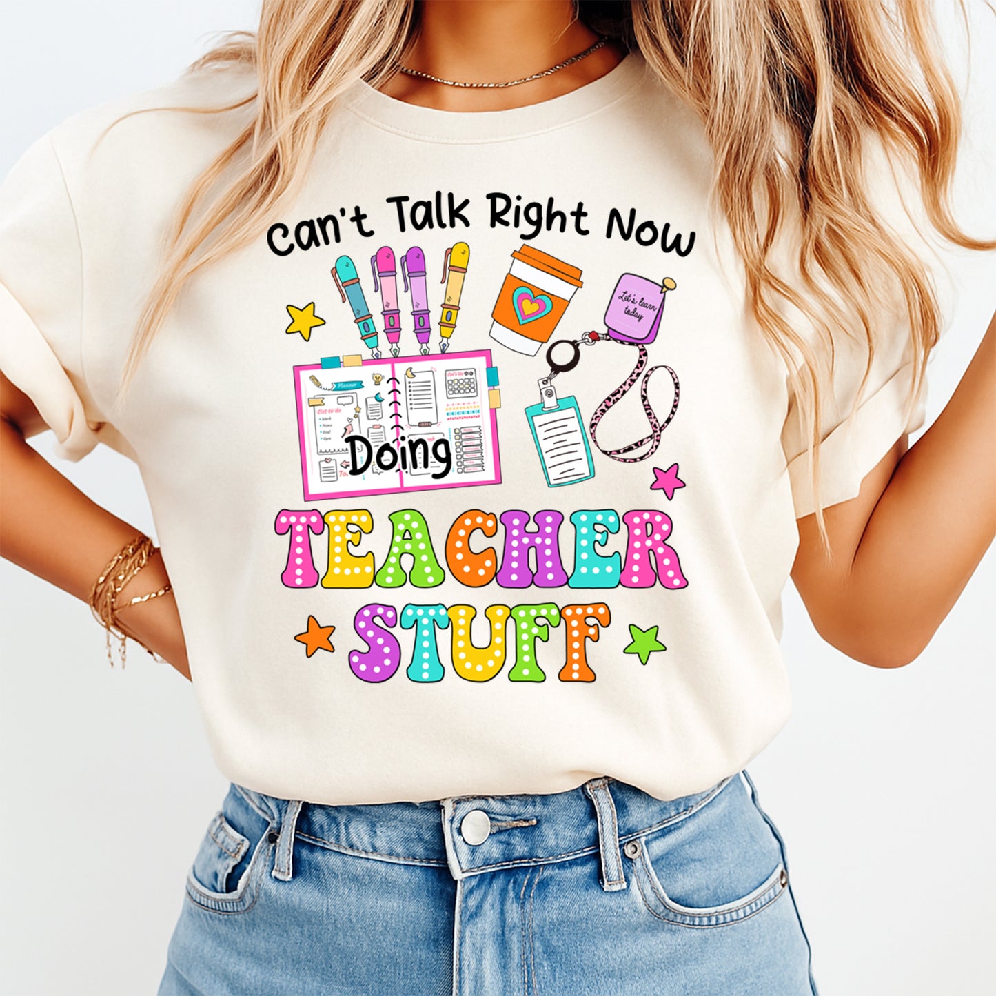 Person wearing a t-shirt with a colorful graphic and text about teaching.