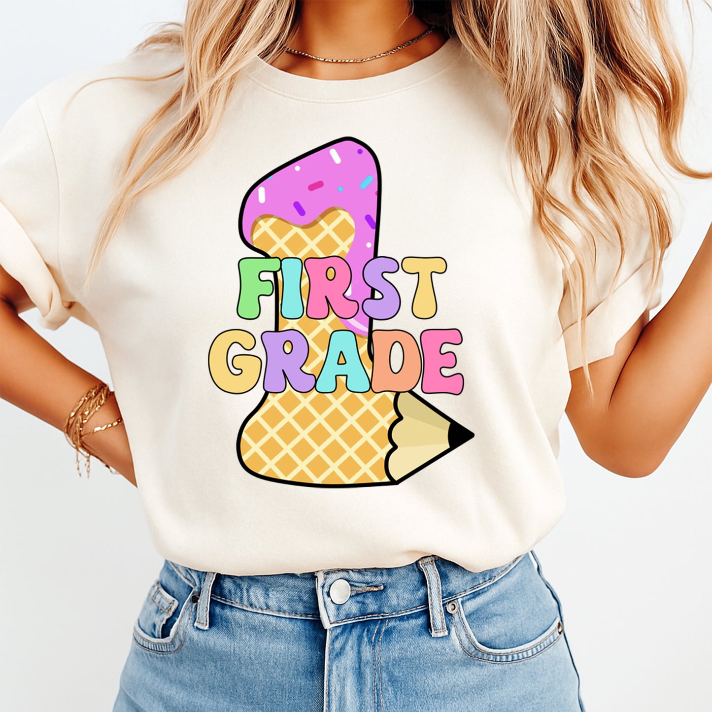 Person wearing a white t-shirt with a colorful ice cream cone design and 'FIRST GRADE' text.