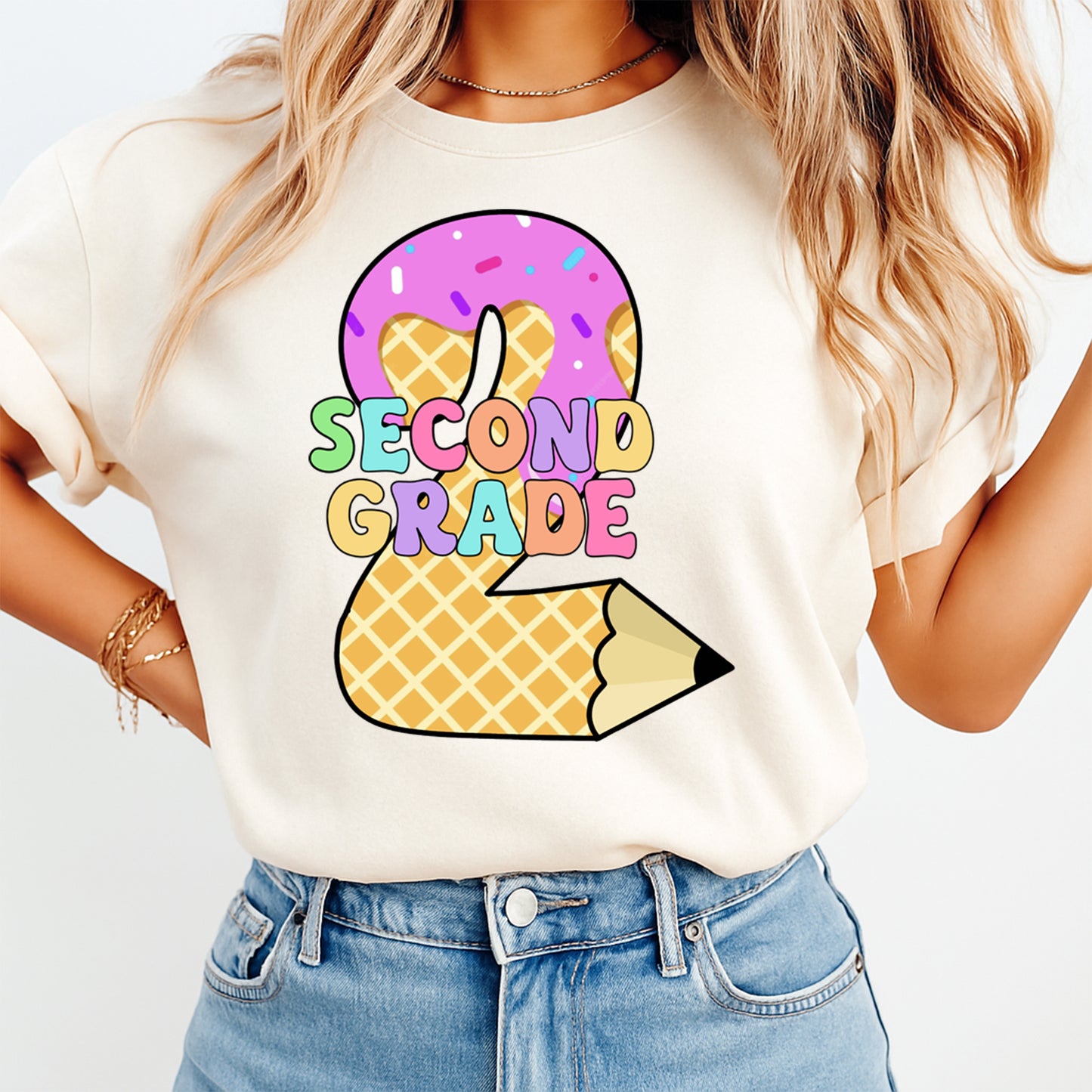 Person wearing a white t-shirt with a colorful 'Second Grade' design on a plain background