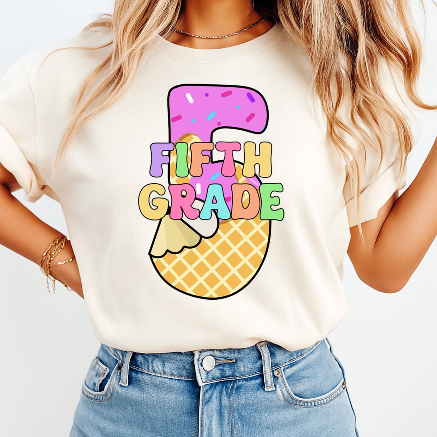 Person wearing a white t-shirt with 'Fifth Grade' design on a plain background