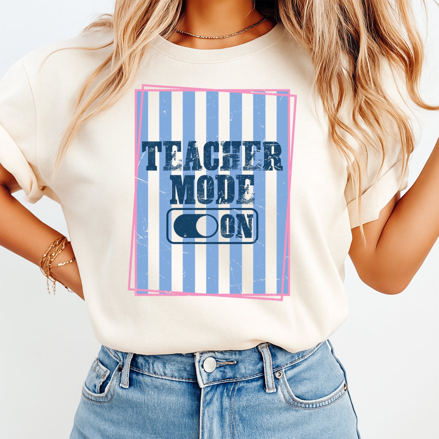 Person wearing a t-shirt with 'Teacher Mode ON' design on a plain background