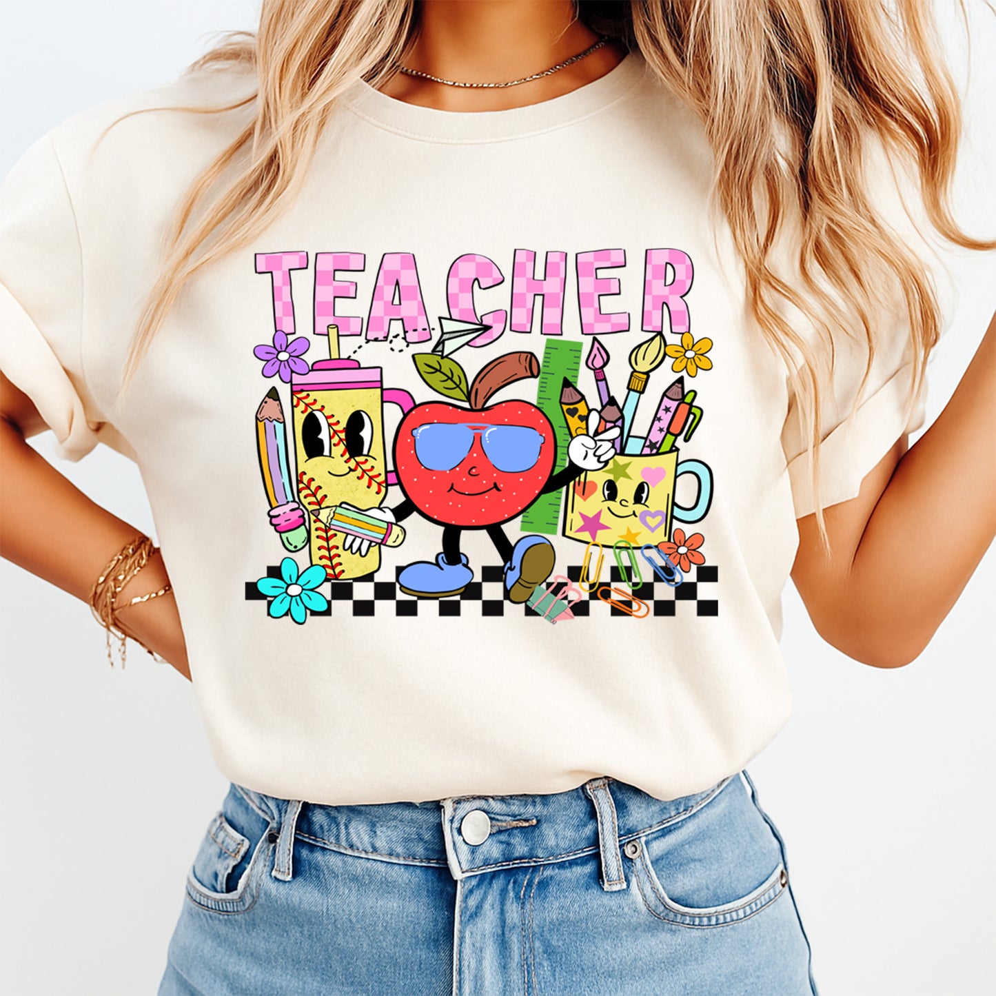 Person wearing a white t-shirt with a colorful 'TEACHER' graphic design.