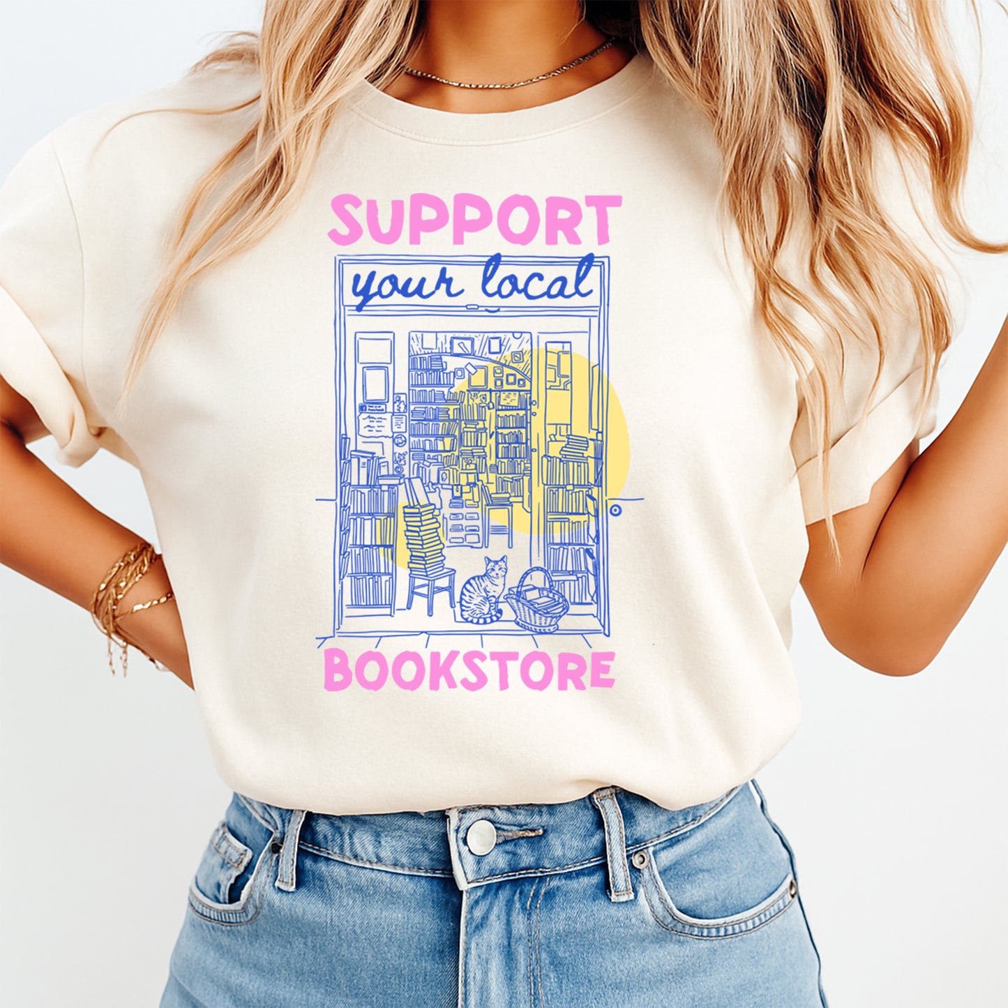 Person wearing a t-shirt with 'Support your local bookstore' design on a plain background