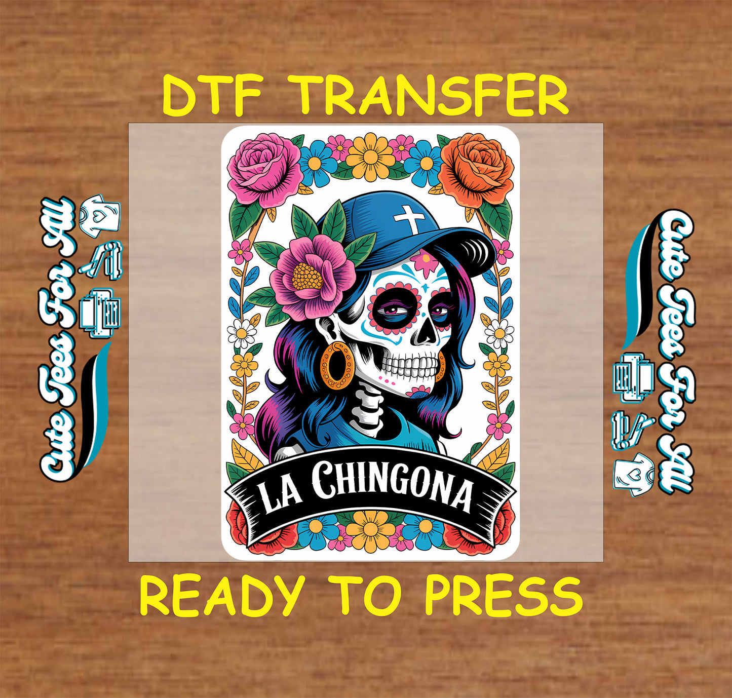 A colorful Day of the Dead style graphic transfer design centered on a tan rectangular sheet, with yellow text reading 'DTF TRANSFER' at the top and 'READY TO PRESS' at the bottom on a wood background. The artwork shows a stylized skull wearing a blue hat, surrounded by pink, orange, yellow, and blue flowers, with the words 'LA CHINGONA' on a black banner.