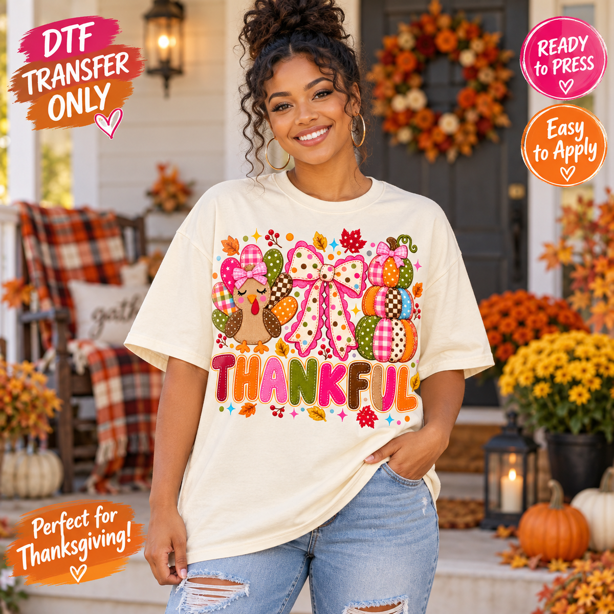 A woman modeling a cream-colored Thanksgiving-themed transfer shirt with a colorful graphic of turkeys, pumpkins, and the word 'THANKFUL'. The background shows a decorated autumn porch with pumpkins, yellow flowers, and wreaths.