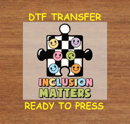 "Inclusion Matters" Autism Awareness DTF transfer with a checkerboard puzzle piece and colorful smiley faces.