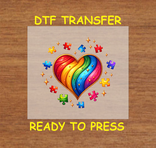 Vibrant rainbow heart surrounded by colorful puzzle pieces and sparkles for Autism Awareness.