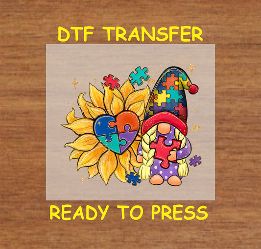 "Puzzle Gnome and Sunflower" DTF transfer with a gnome in a puzzle hat, sunflower with heart puzzle center, and scattered puzzle pieces.