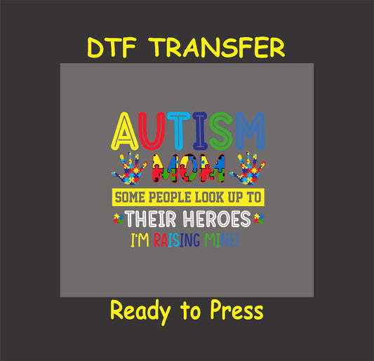 Colorful "Autism Mom" DTF transfer with puzzle pieces and the phrase "Some people look up to their heroes, I'm raising mine," ready-to-press for apparel.