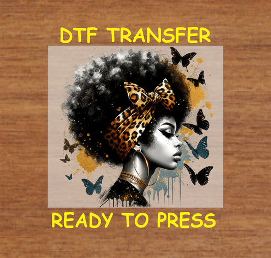 "DTF transfer of a woman with a leopard-print bow, afro, butterflies, and golden accents, ready to press for apparel."
