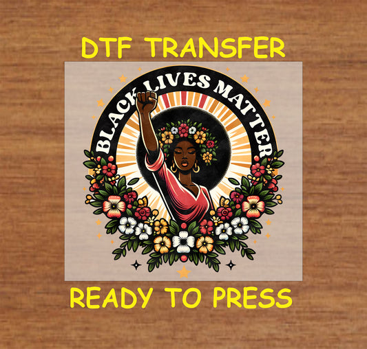 "DTF Transfer featuring 'Black Lives Matter' text with a strong Black woman raising her fist, surrounded by colorful flowers, ready to press."