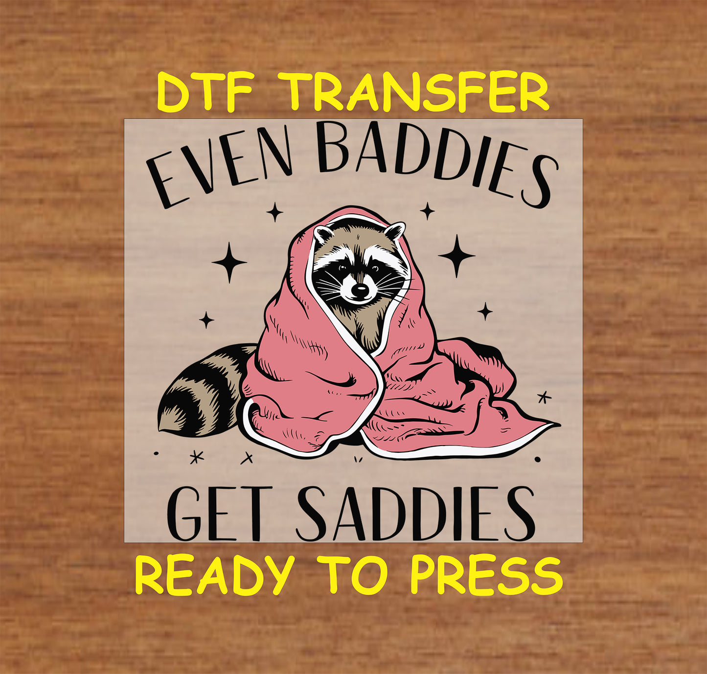 DTF transfer featuring an animal wrapped in a pink blanket with the text "Even Baddies Get Saddies" surrounded by stars.