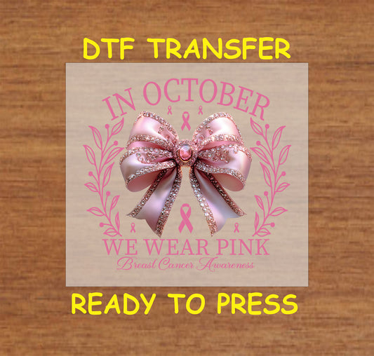 "Pink glitter ribbon bow design for Breast Cancer Awareness with 'In October, We Wear Pink' text and floral accents."