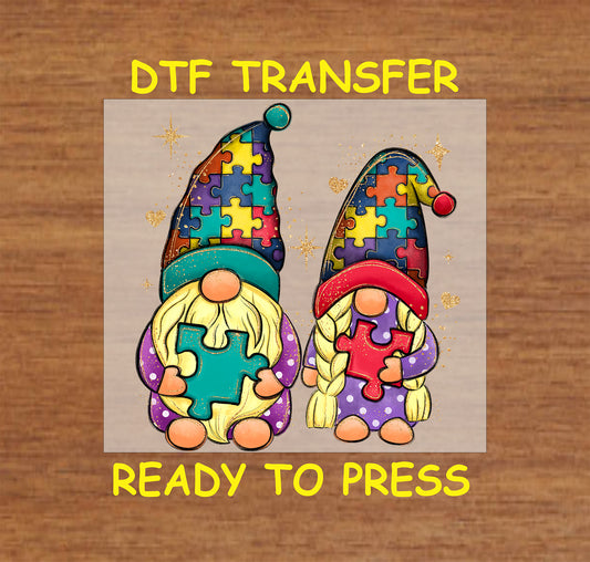 DTF transfer featuring two colorful gnomes with autism puzzle piece designs, glitter accents.