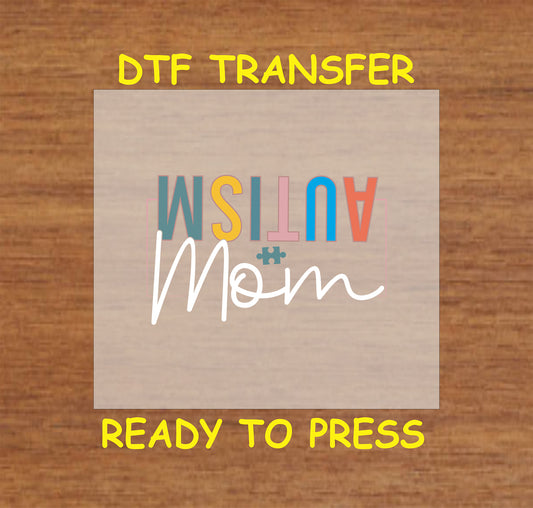 "DTF transfer featuring the word 'AUTISM' in colorful letters and 'Mom' in cursive, with a puzzle piece accent."