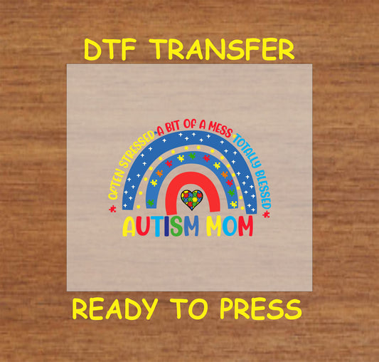 "DTF transfer featuring a colorful rainbow with puzzle pieces and the phrase 'Often Stressed, A Bit of a Mess, Totally Blessed' for autism moms."