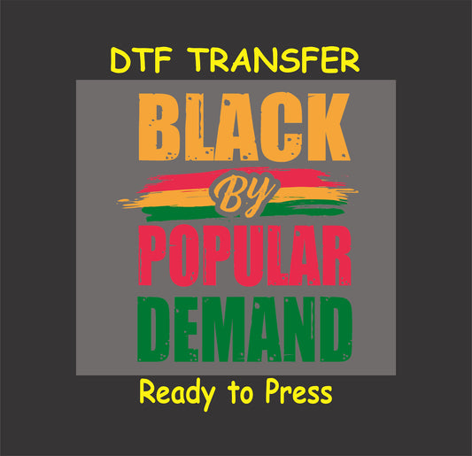 Black By Popular Demand DTF transfer with bold brush-stroke design in orange, red, yellow, and green, ready to press for custom apparel.