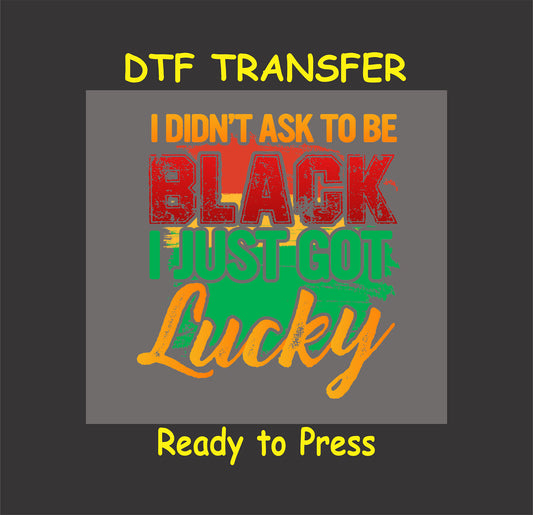 Distressed DTF transfer with the phrase "I Didn't Ask to Be Black, I Just Got Lucky" in bold red, green, yellow, and orange, ready to press.