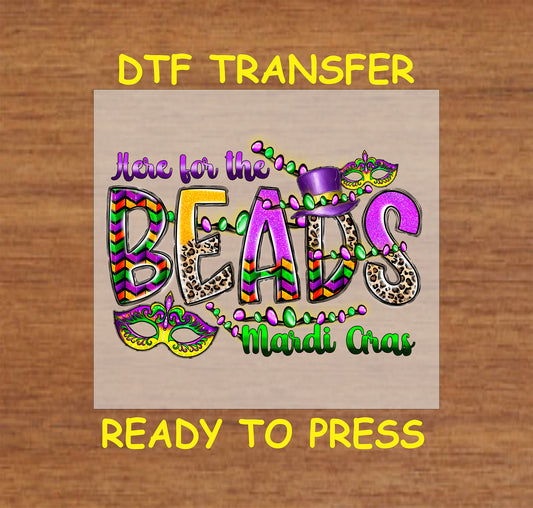 Mardi Gras DTF transfer with colorful text, beads, a masquerade mask, and a top hat.