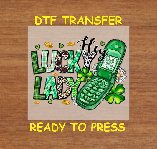 St. Patrick’s Day DTF transfer with "Hey Lucky Lady" text, green flip phone, shamrocks, and gold coins.