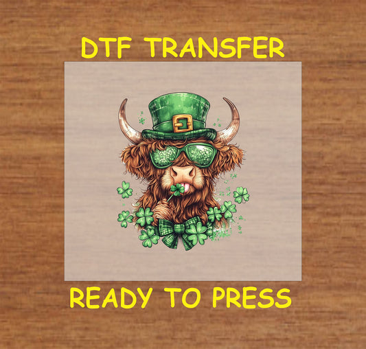 Highland cow wearing a green leprechaun hat, shamrock sunglasses, and a bow tie.