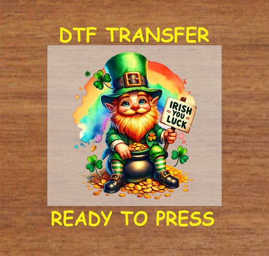 Leprechaun sitting on a pot of gold holding an “Irish You Luck” sign with a rainbow background.