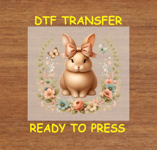 Golden Easter bunny with a bow, floral wreath, and butterflies.