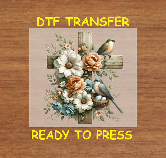 Rustic wooden cross with pastel flowers, birds, and a nest with eggs in a Christian DTF transfer.