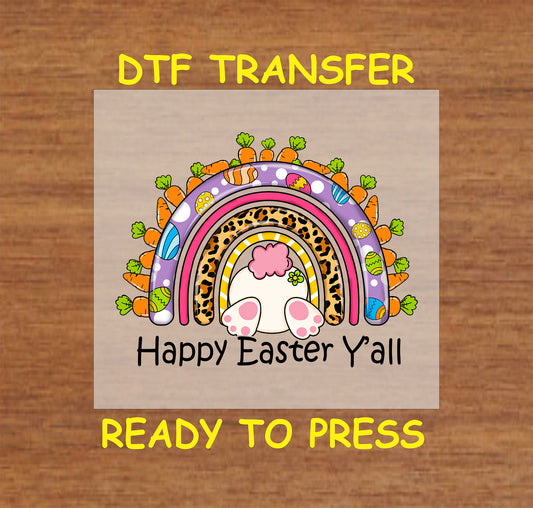 DTF transfer with a colorful rainbow, bunny tail, leopard print, carrots, and Easter eggs with "Happy Easter Y'all" text.