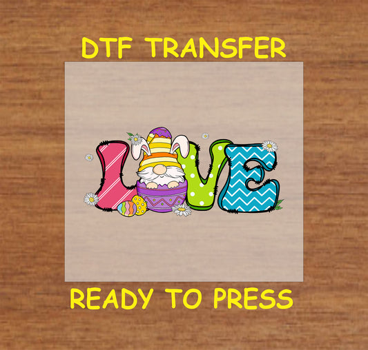 DTF transfer with "LOVE" in colorful patterned letters, featuring an Easter gnome, egg, and daisies.