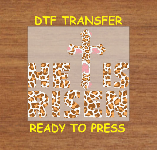 Leopard print "He Is Risen" text with a floral cross, Easter DTF transfer.