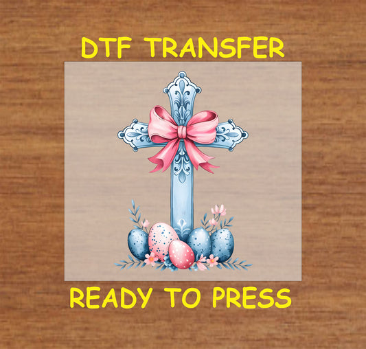 Blue cross DTF transfer with pink bow, floral accents, and decorated Easter eggs.