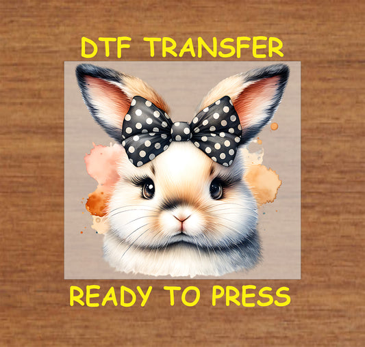 Bunny with black polka dot bow and watercolor splashes.