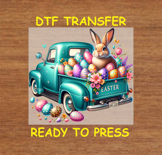 Teal vintage truck filled with colorful Easter eggs, flowers, and a bunny.