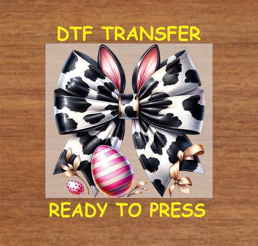 Cow print bow with bunny ears, gold floral accents, and a striped pink Easter egg.