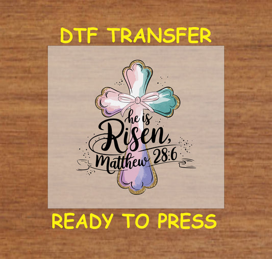 Easter DTF transfer with a pastel cross, bow, and "He Is Risen" Matthew 28:6 scripture.