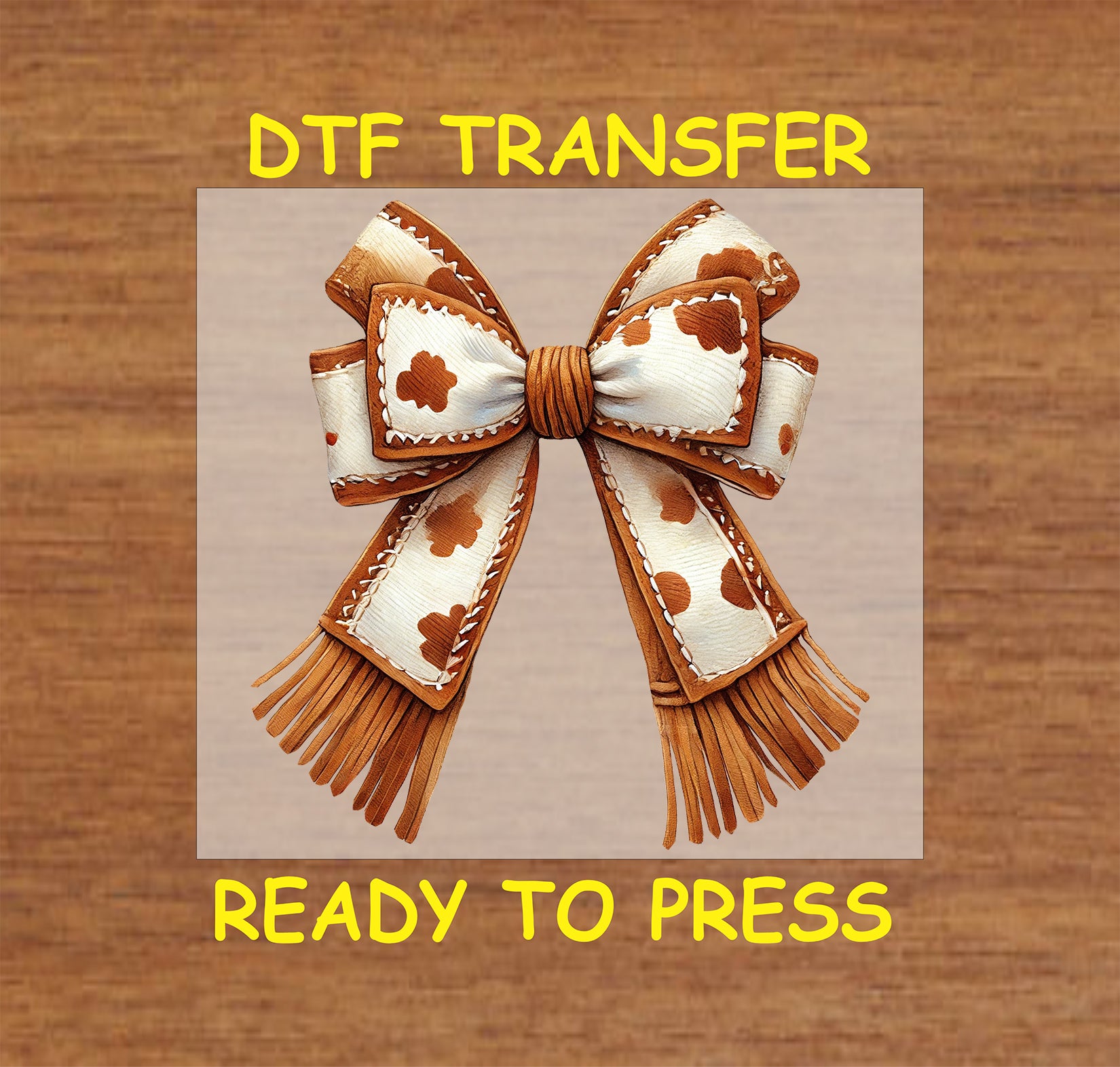 Cow print bow with stitched leather details and fringe accents.